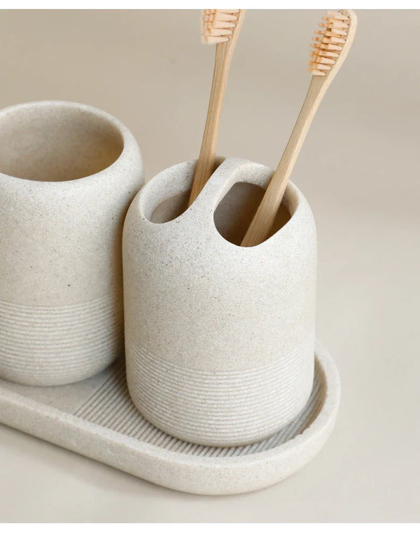 Toothbrush holder detail from Buddify's beige 5Pcs Bathroom Accessories set, showcasing minimalist design with bamboo toothbrushes.
