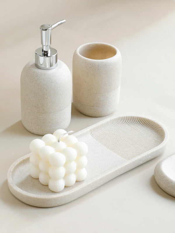 Minimalist beige 5Pcs Bathroom Accessories set by Buddify with soap dispenser, tumbler, and tray styled with a decorative candle.