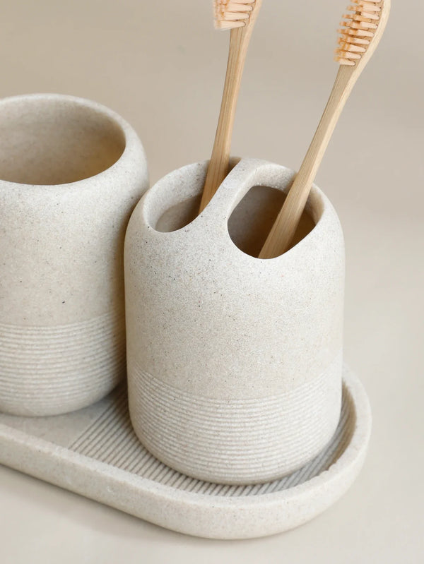 Close-up of beige toothbrush holder from 5Pcs Bathroom Accessories set by Buddify, holding bamboo toothbrushes on matching tray.