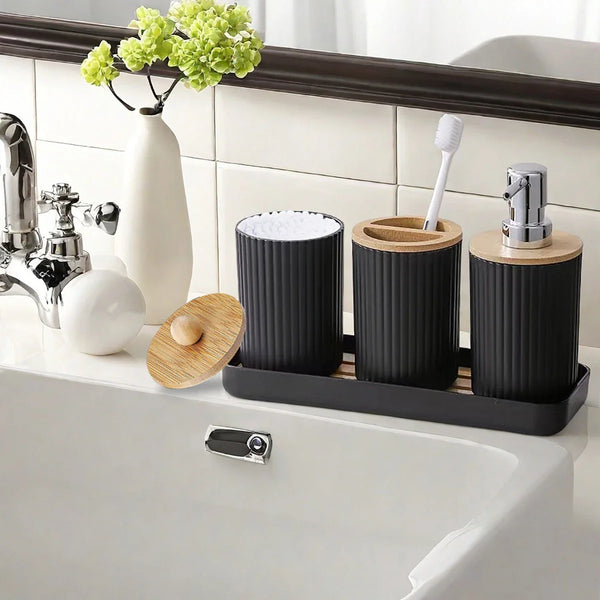 Elegant Buddify black bathroom accessories set placed by sink, includes dispenser, toothbrush holder, and cotton jar with bamboo accents.