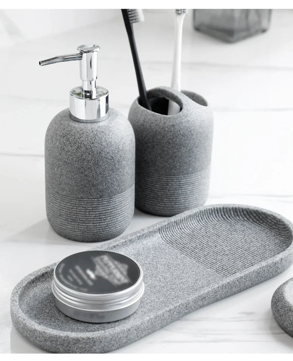 Grey bathroom set from Buddify's 5Pcs Bathroom Accessories collection with soap dispenser, toothbrush holder, and tray styled with grooming tin.
