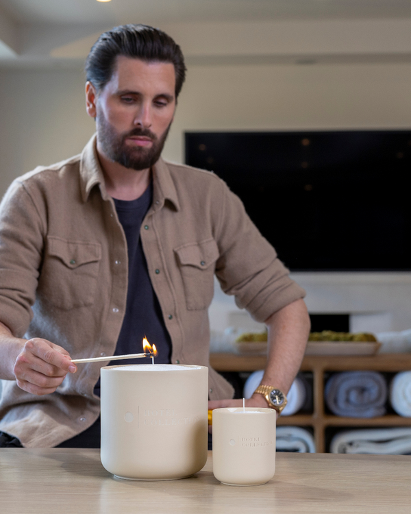 Scott Disick lighting a candle in a home setting Hotel Collection