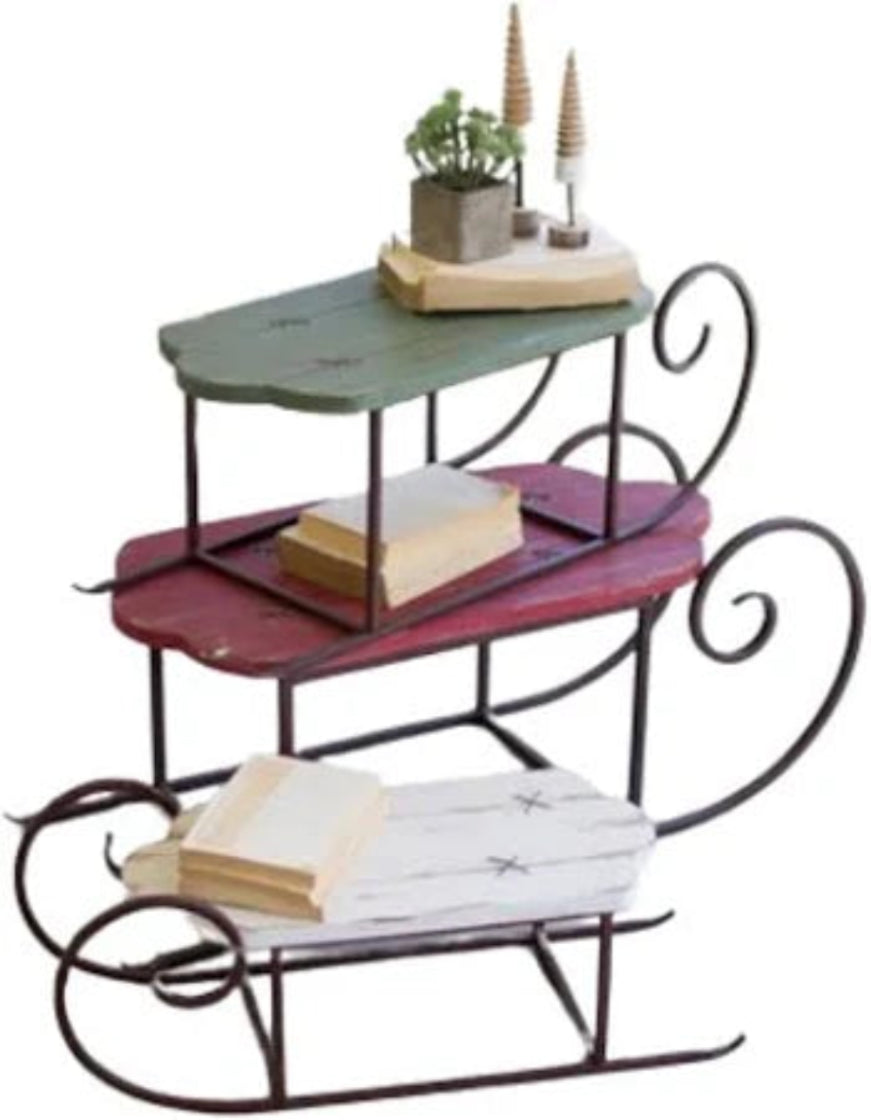 Three-tiered decorative shelf with books, plants, and decor items on a white background