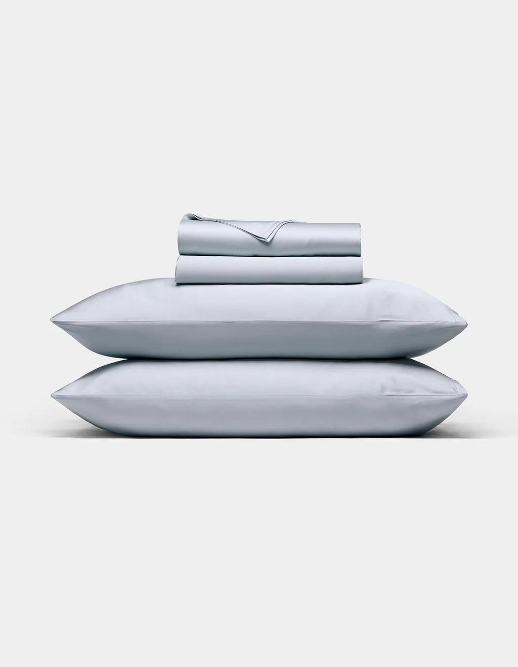 Shore bedding set including pillows and a folded sheet on a white background