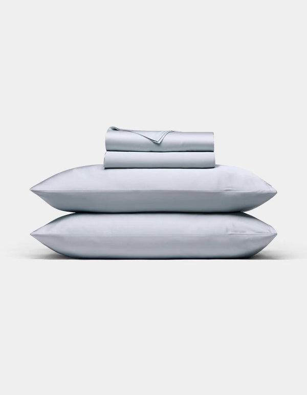 Shore bedding set including pillows and a folded sheet on a white background