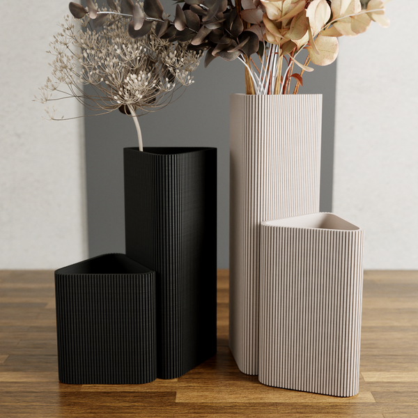 Set of three textured vases on a wooden surface with a neutral background