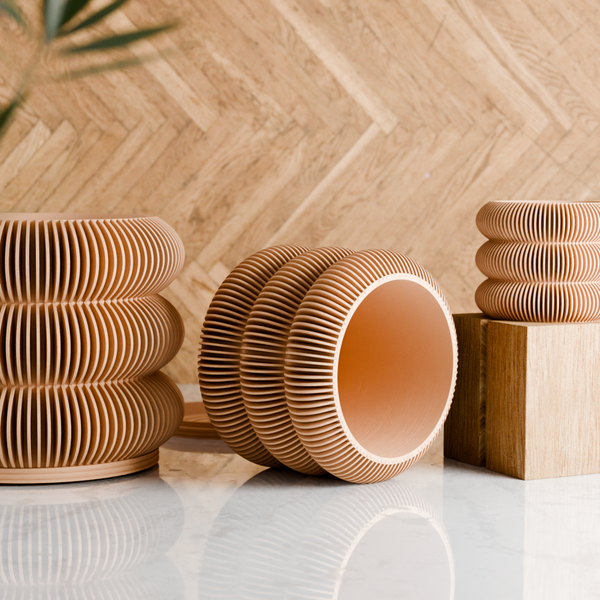 Stacked wooden bowls on a light surface with a wooden wall background