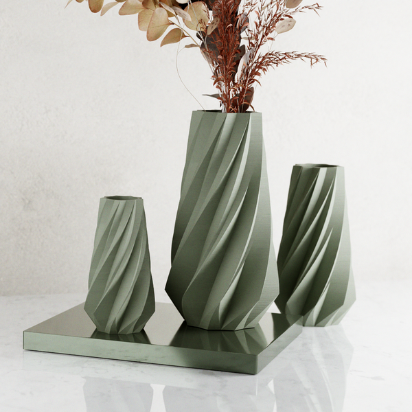 Set of three green textured vases on a white background