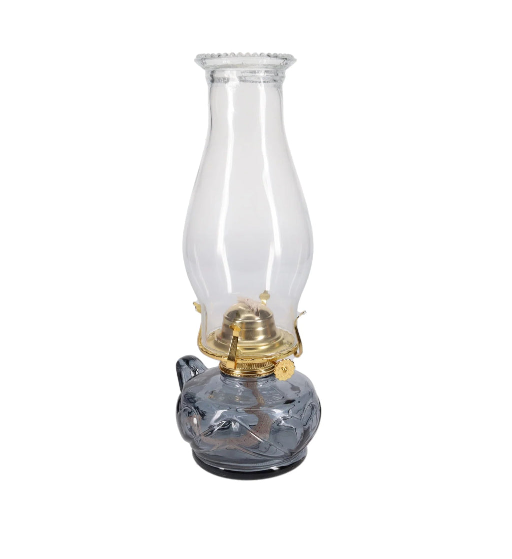 Clear glass oil lamp with brass burner on a white background