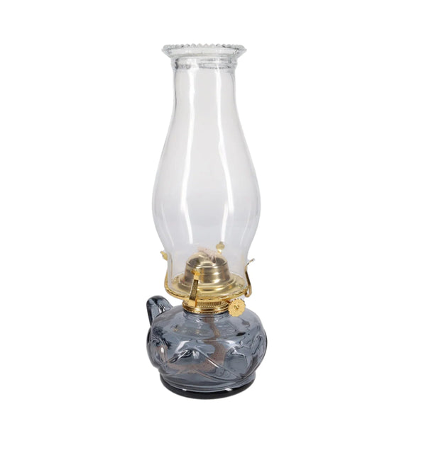 Clear glass oil lamp with brass burner on a white background