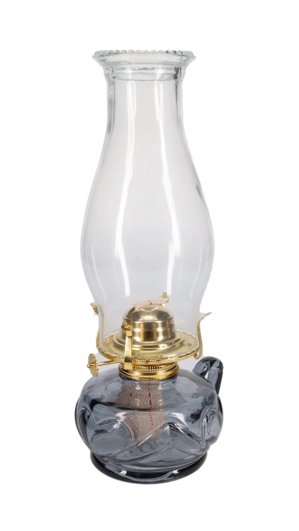 Clear glass oil lamp with brass burner on a white background
