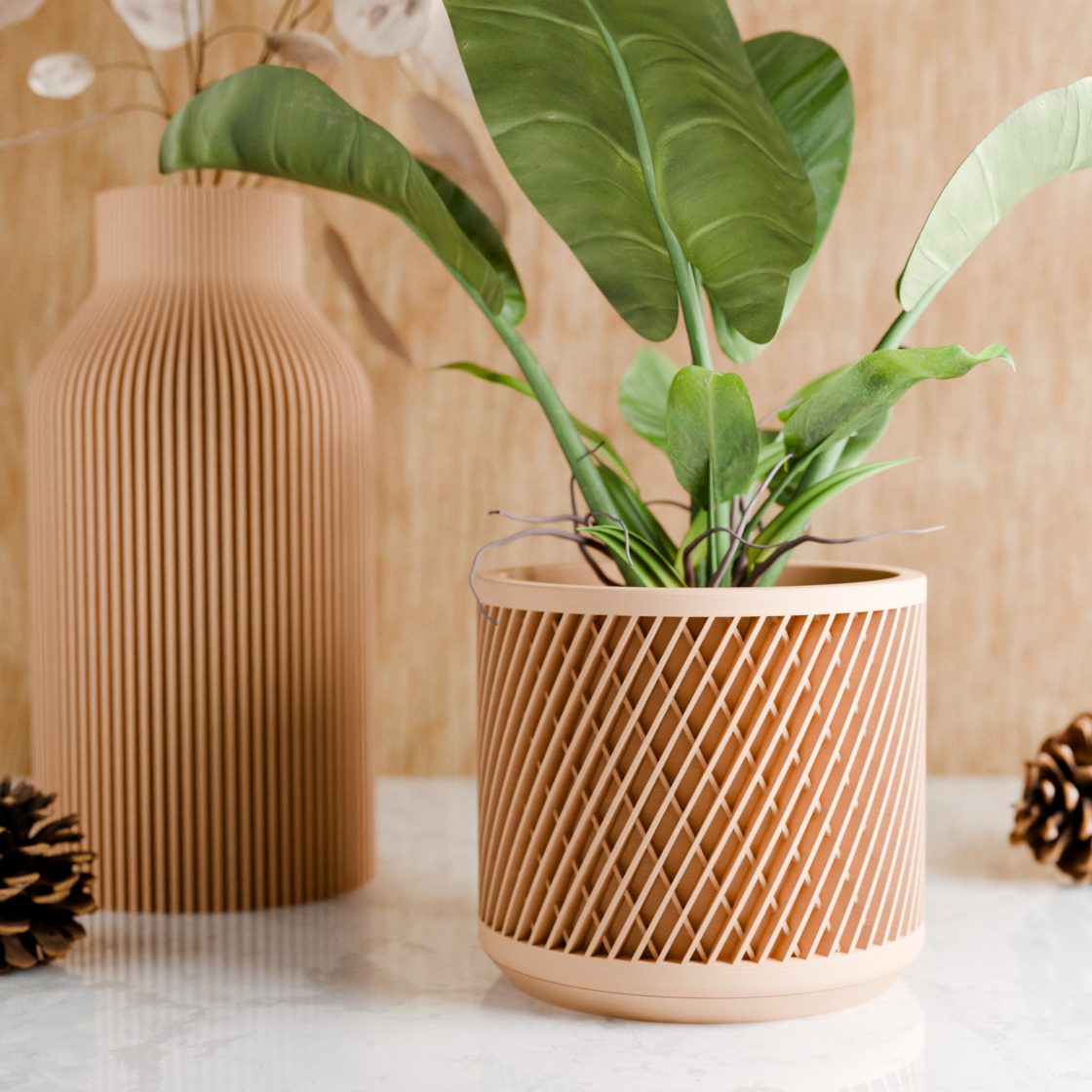 Wooden plant pot with a plant and decorative vase on a light surface with a wooden background