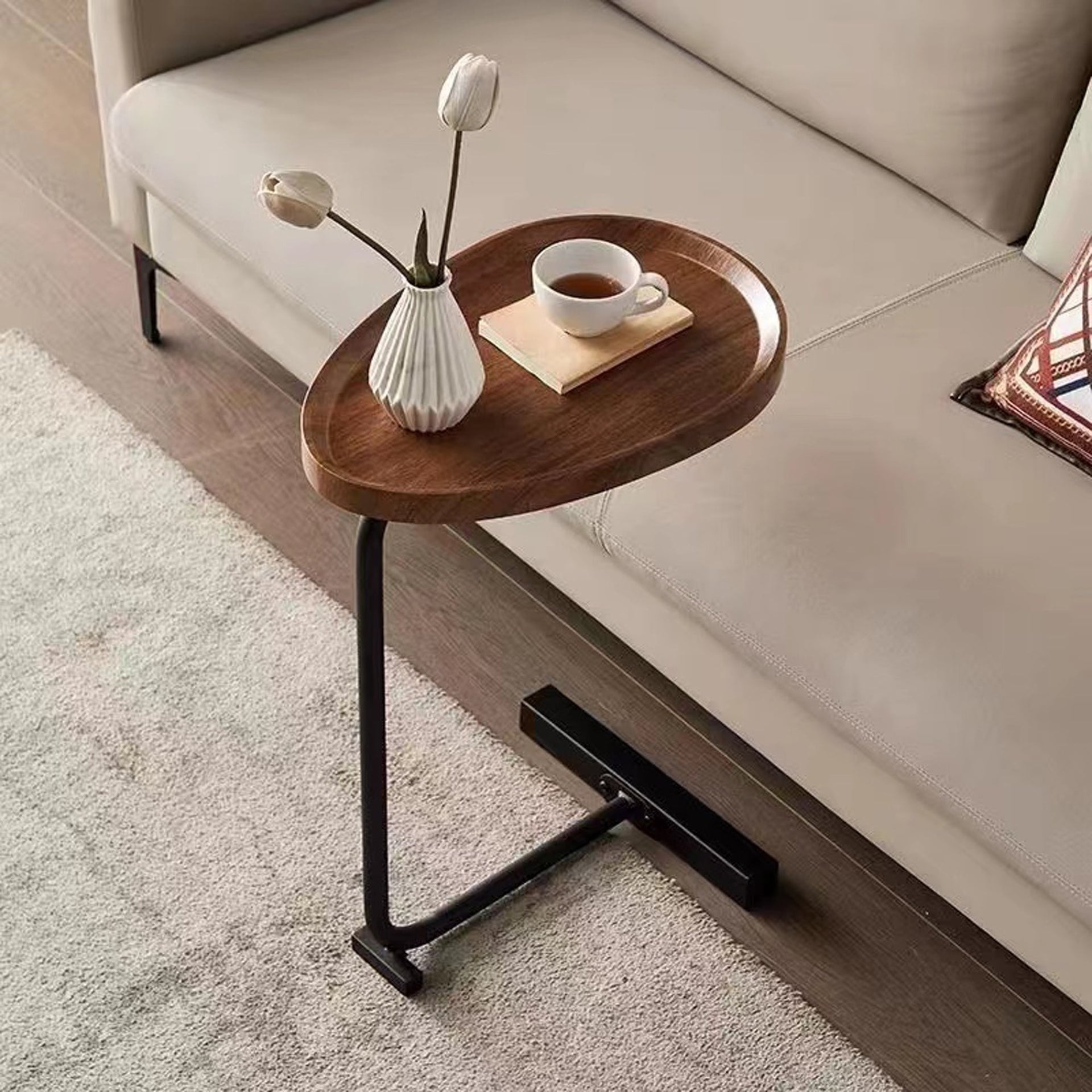 Brown C-shaped Side Table placed beside a beige sofa, showcasing its space-saving design and functionality for living room use.