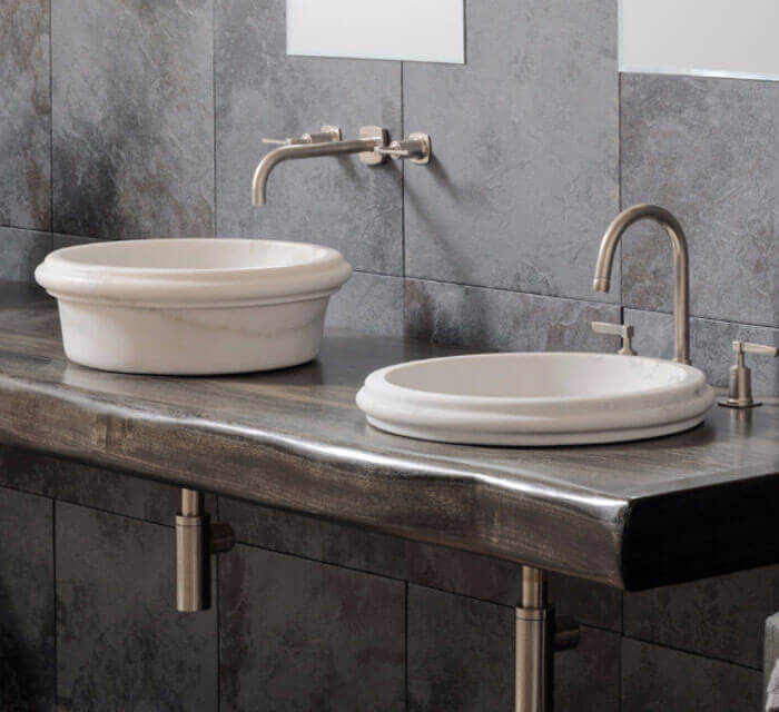 Bathroom vanity with two white sinks, silver faucets, and a dark wooden countertop.