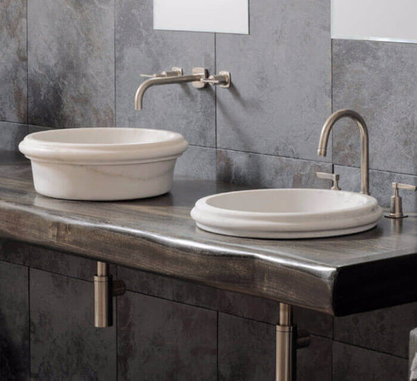 Bathroom vanity with two white sinks, silver faucets, and a dark wooden countertop.