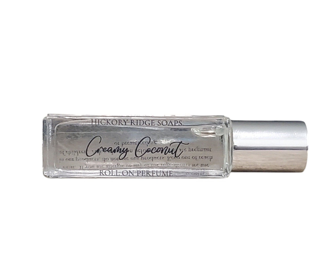 Roll-on perfume bottle labeled 'Creamy Coconut' by Hickory Ridge Soaps on a white background