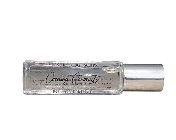 Roll-on perfume bottle labeled 'Creamy Coconut' by Hickory Ridge Soaps on a white background