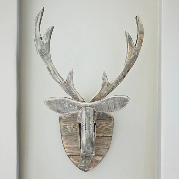 Wooden deer head wall decoration on a plain background