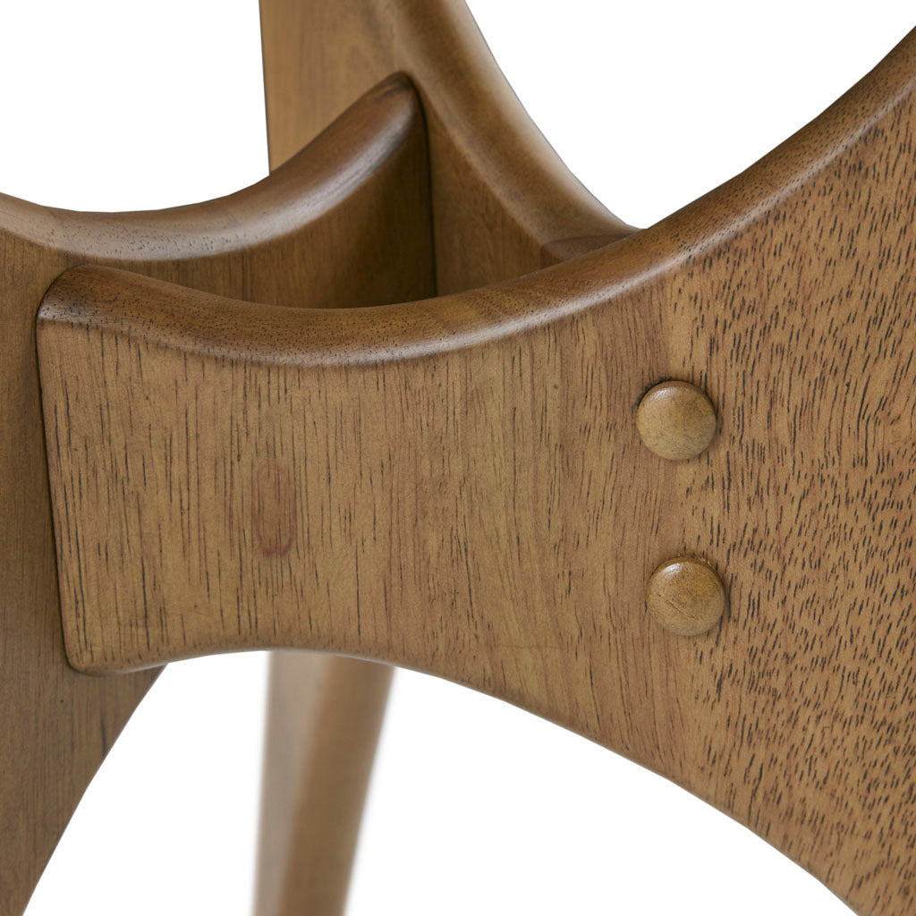 Detail of Triangle Wood Side Table's curved leg joint and rivet accents, highlighting craftsmanship and design.
