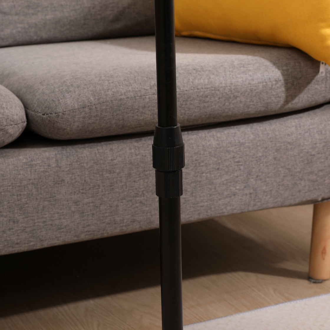 Close-up of the adjustable height mechanism on the black metal pole of the bamboo couch tray table. Ensures customizable comfort.