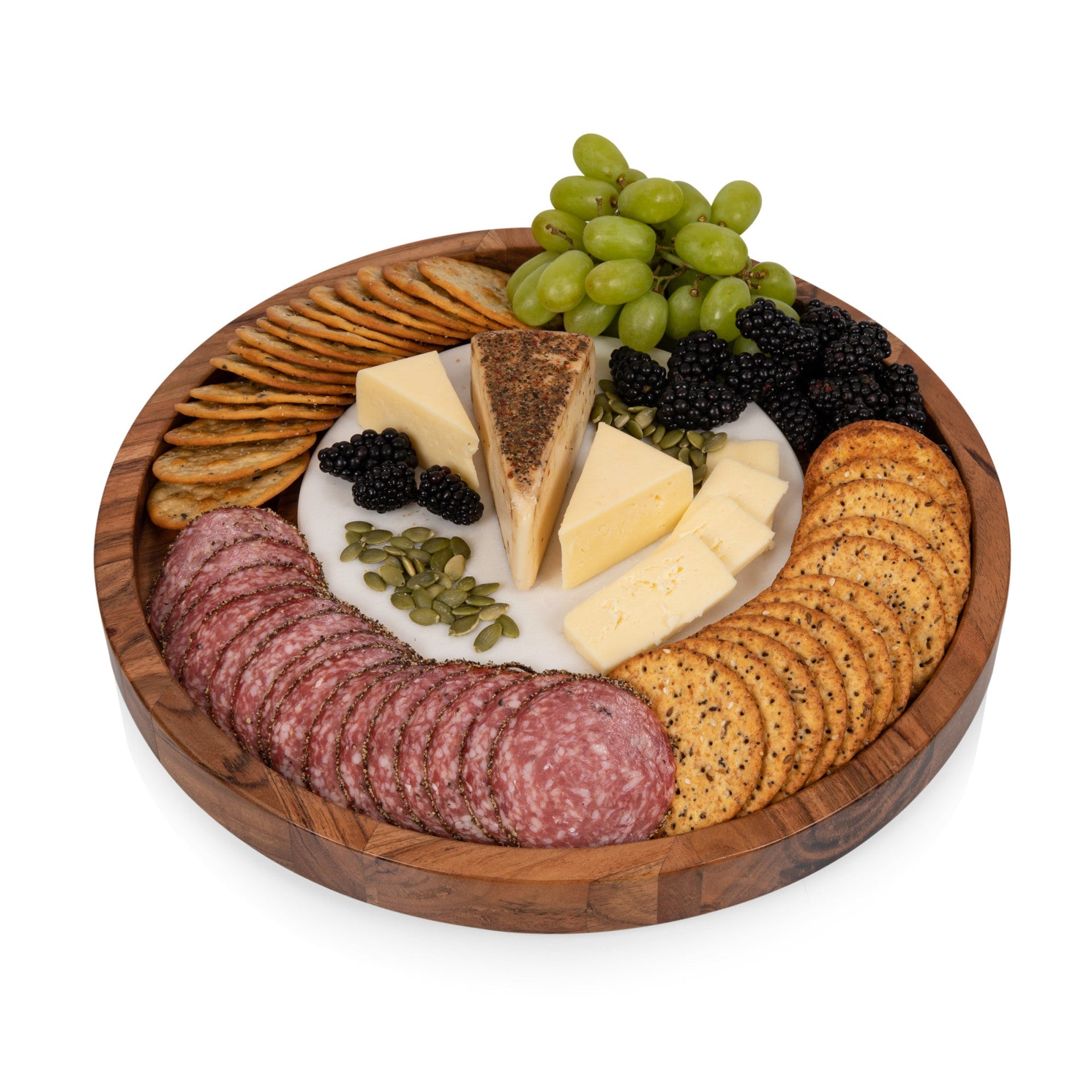 Wooden charcuterie board with assorted meats, cheeses, crackers, and grapes on a white background