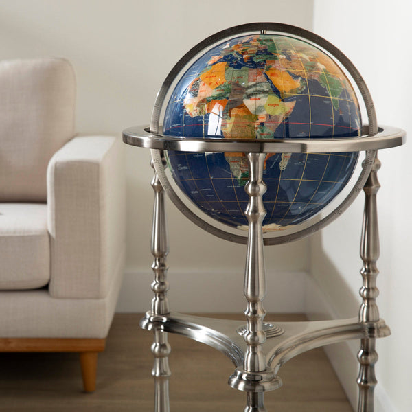 World globe on a stand in a room with a beige sofa.