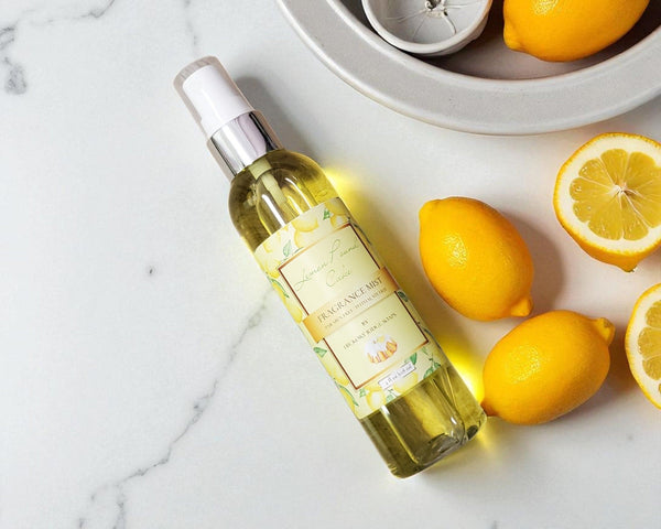 Bottle of lemon-scented product on a marble surface with lemons around
