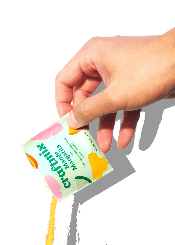 Hand holding a colorful juice pouch with a white background