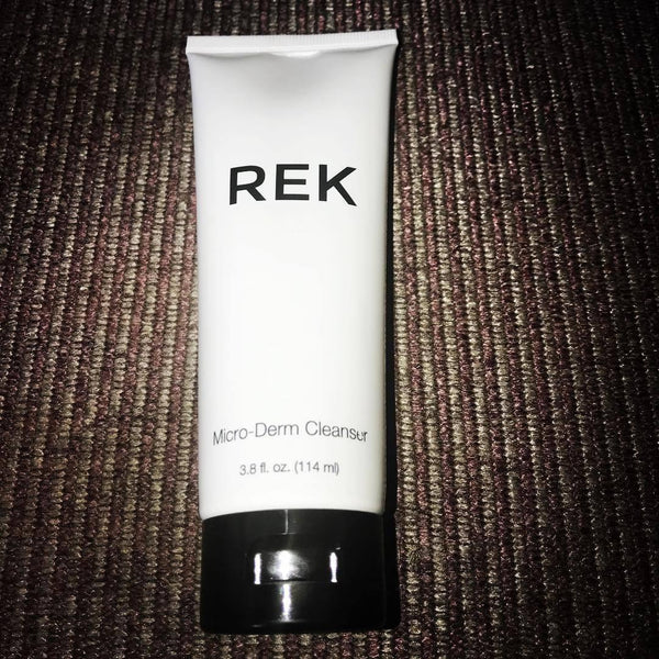 Tube of REK Micro-Derm Cleanser on a textured brown surface