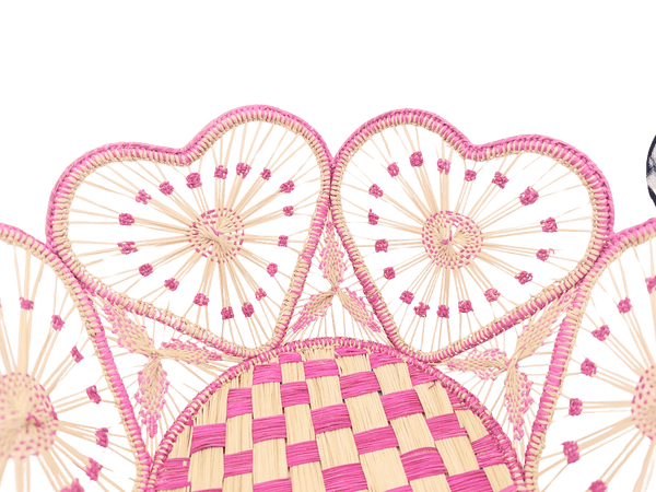 Decorative woven mat with pink and beige patterns on a white background