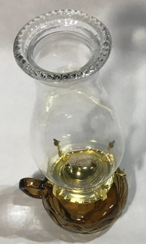 Vintage-style oil lamp with clear glass and brass base on a white background