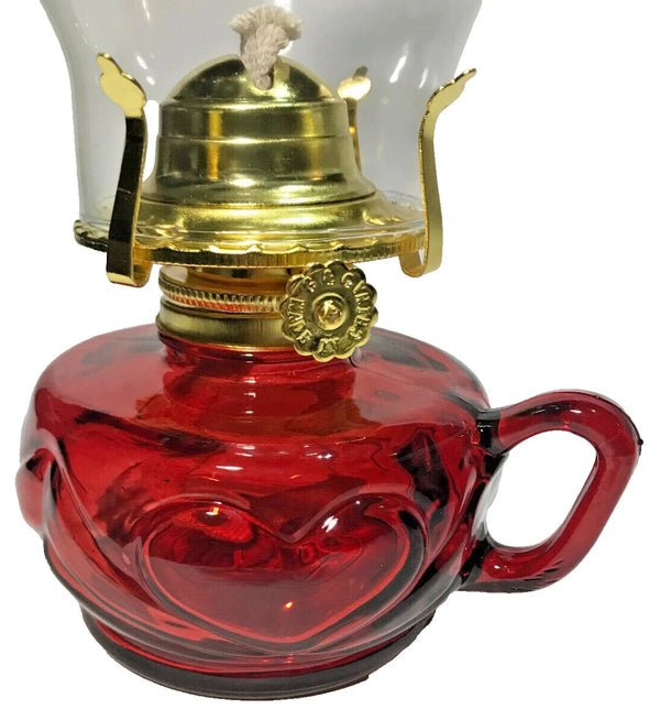 Red glass oil lamp with brass top on a white background