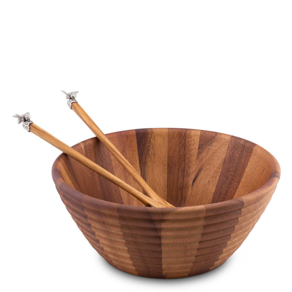 Wooden salad bowl with two wooden spoons on a white background