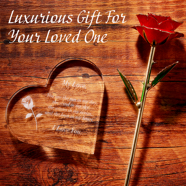 Heart-shaped wooden plaque with engraved text and a gold rose on a wooden surface.